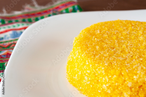 tasteful and colorful brazilian corn couscous on a wooden table photo