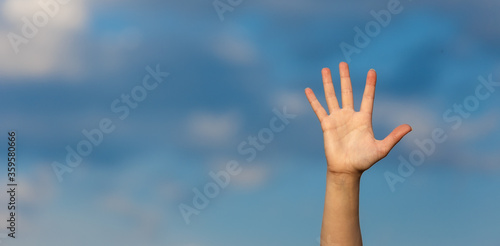 A woman opened palm over a blue sky background