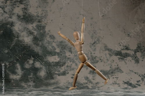 Puppet in the hands of puppeteer walks on isolated, background. The concept of manipulation. Copy space. photo