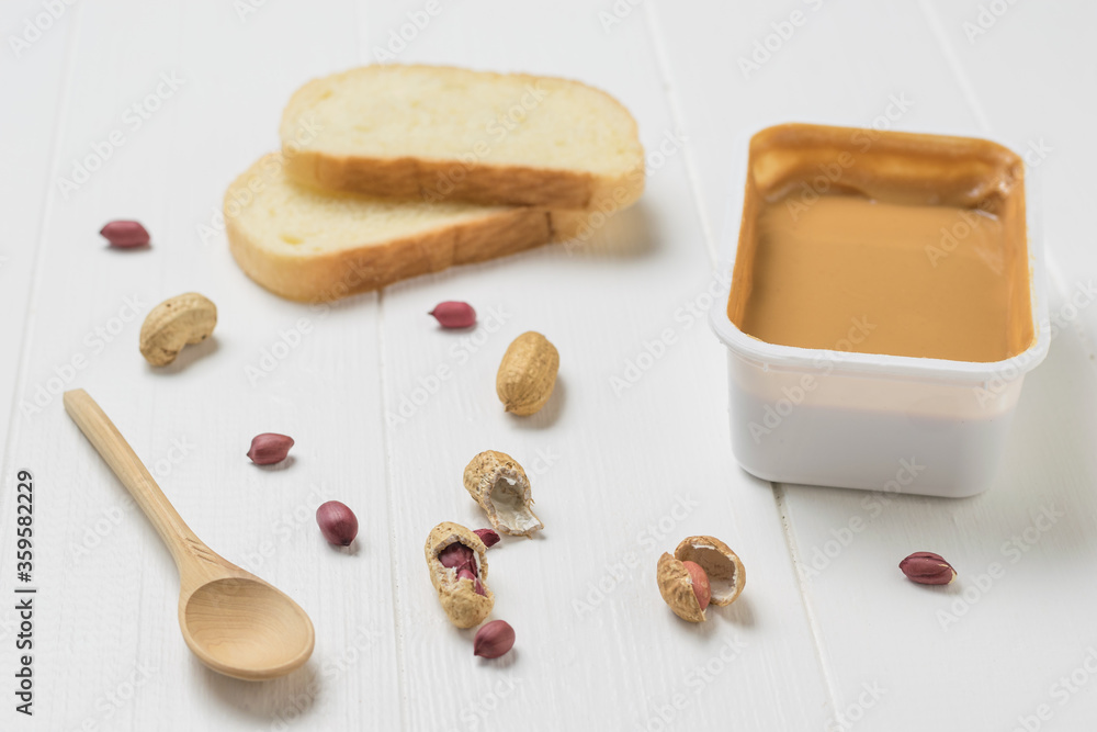 Peanut paste, white bread and peanut fruit on a white table. Peanut paste, white bread and peanut fruit on a white table.