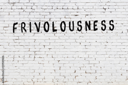 White wall with black paint inscription frivolousness on it