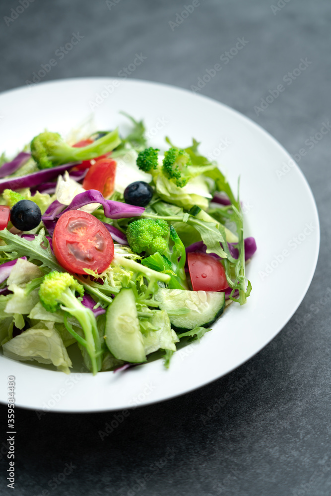 A plate of delicious and healthy green vegetable salad. A plate of delicious and healthy vegetable salad on a gray concrete floor.
A plate of delicious and healthy green vegetable salad. A plate of delicious and healthy vegetable salad on a gray concrete floor.