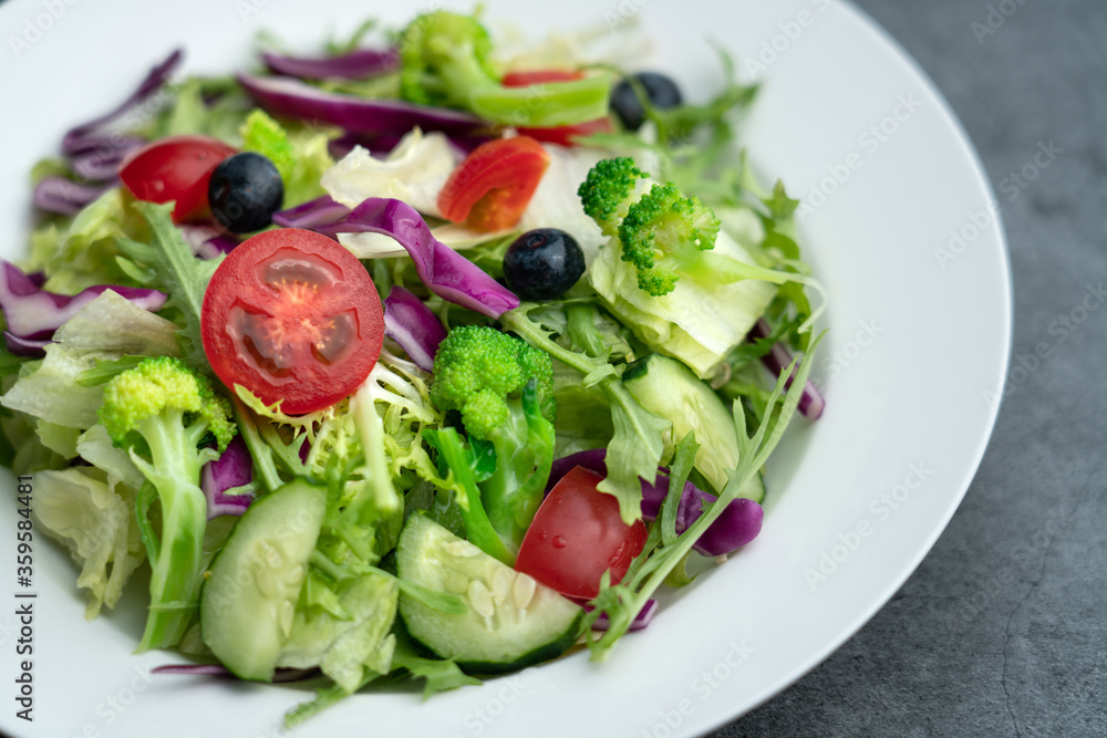 A plate of delicious and healthy green vegetable salad. A plate of delicious and healthy vegetable salad on a gray concrete floor.
A plate of delicious and healthy green vegetable salad. A plate of delicious and healthy vegetable salad on a gray concrete floor.