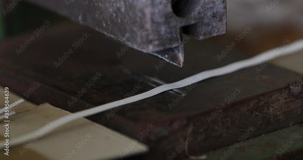 Cutting Elastic Garter Into Strips With Machine Cutter In A Sewing Factory - COVID-19 Pandemic - Closeup Pan Left Shot Cutting Elastic Garter Into Strips With Machine Cutter In A Sewing Factory - COVID-19 Pandemic - Closeup Pan Left Shot