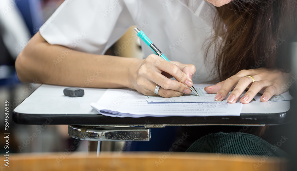 high school,university student study.hands holding pencil writing paper answer sheet.sitting lecture chair taking final exam attending in examination classroom.concept scholarship for education abroad high school,university student study.hands holding pencil writing paper answer sheet.sitting lecture chair taking final exam attending in examination classroom.concept scholarship for education abroad