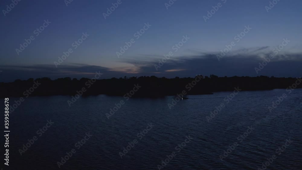 Aerial reverse shot with boat on lake passing by during twilight. 4K Aerial reverse shot with boat on lake passing by during twilight. 4K