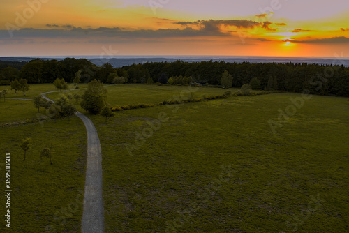 outdoor Hiking area with a sunset view over a beautiful hilly, inspiring summer landscape with a. Footpath or cycle path, dirt track. in the natural Belgian Ardennes photo