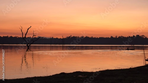 laotian fisherman driving a fisherboat on Nam Theun river at dawn photo