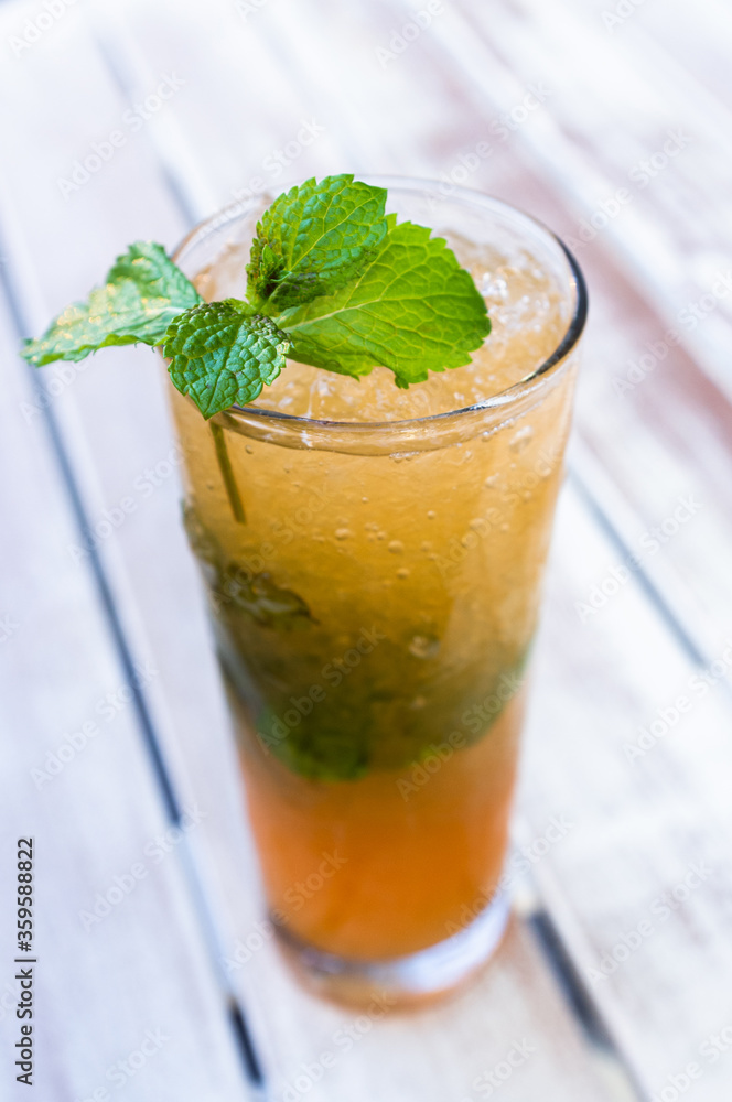 ice cold long island tea cocktail with mint in outdoor backyard ice cold long island tea cocktail with mint in outdoor backyard