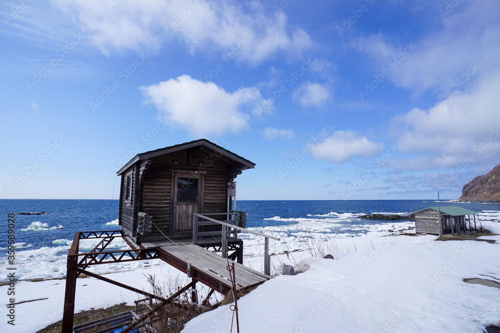 Rustic wood cabin on a snowy beach in Hokkaido with Sea ice on the shoreline. Rustic wood cabin on a snowy beach in Hokkaido with Sea ice on the shoreline.