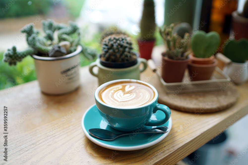 Hot Latte - A cup of coffee with milk and beautiful leaf pattern latte art on wooden table and blurred background, Perfect for breakfast time. Hot Latte - A cup of coffee with milk and beautiful leaf pattern latte art on wooden table and blurred background, Perfect for breakfast time.