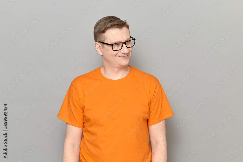Portrait of happy mature man with glasses, wearing orange T-shirt Portrait of happy mature man with glasses, wearing orange T-shirt