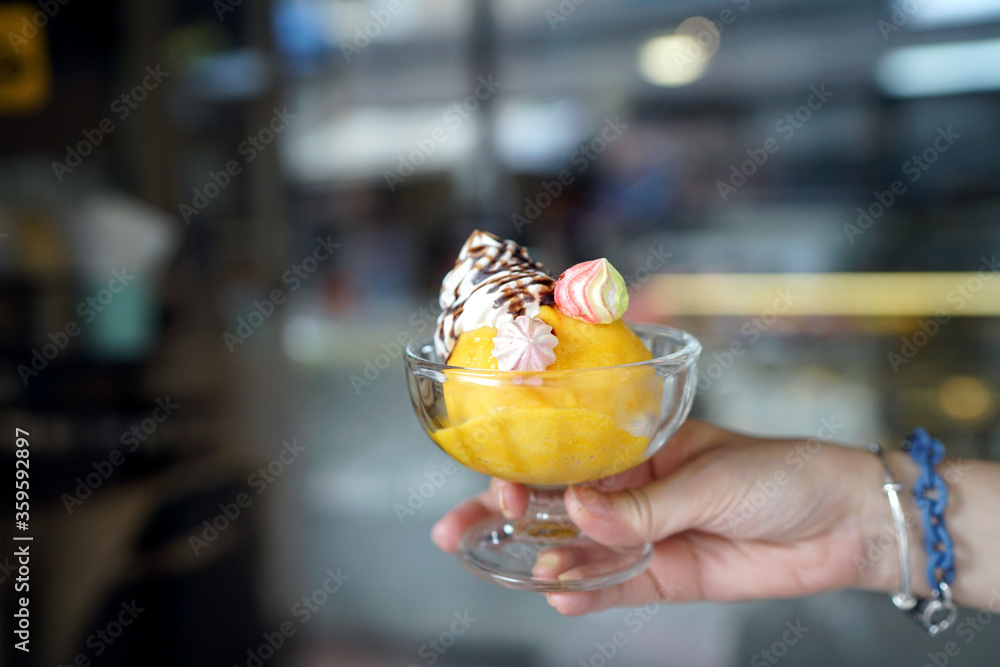 Φωτογραφία Homemade Ice cream - A bowl of passion fruit sorbet topped with whipped cream, chocolate sauce and meringue on blurred background, Ice cream melting in the summer day