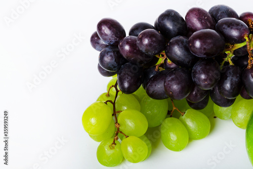 Bunch of green and blue grape isolated on white background. Place for text. Ripe fresh dark grape close up