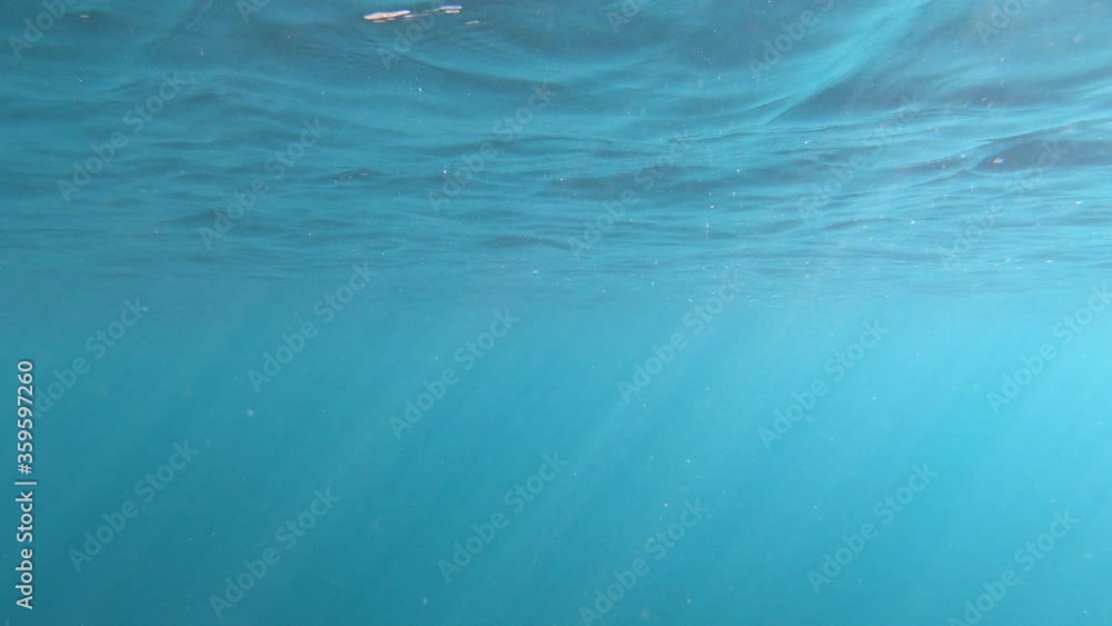underwater ocean shot of the surface in slow motion panning upwards.