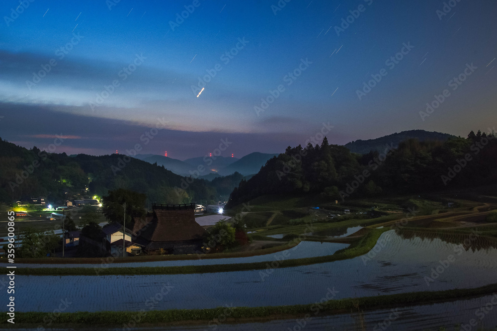 Obraz premium 長時間露光した田園地帯の星空