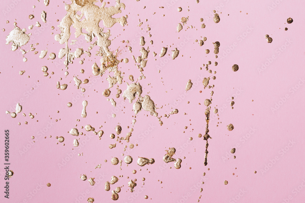 Pastel pink cardboard with gold potal drops and splashes. Creative background