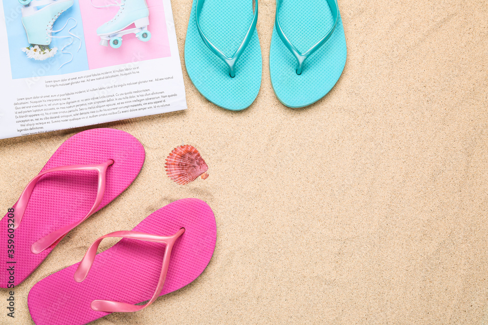 Flip-flops with newspaper on sand background