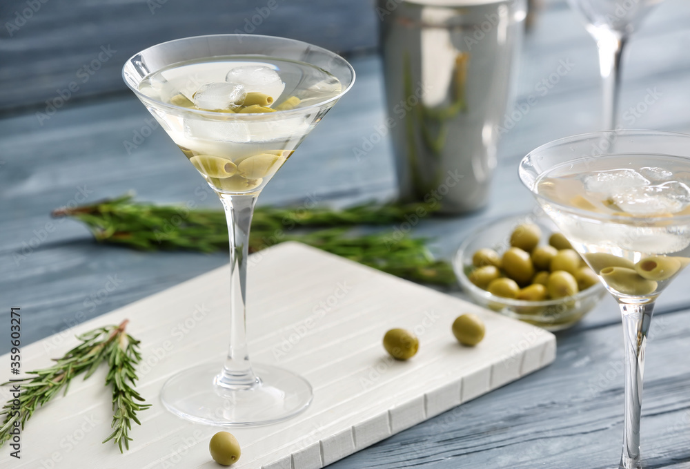 Glasses of tasty martini cocktail with olives on table