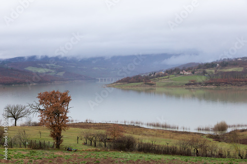 Beautiful peaceful autumn fall landscape cultivated fields and lake with mist fog