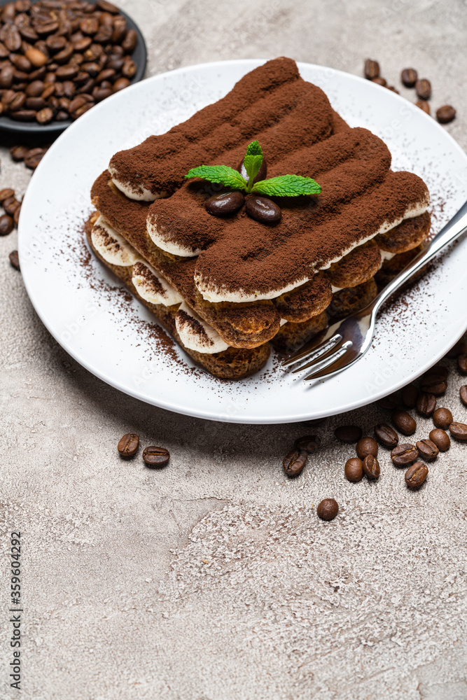 Classic tiramisu dessert on ceramic plate on concrete background Classic tiramisu dessert on ceramic plate on concrete background
