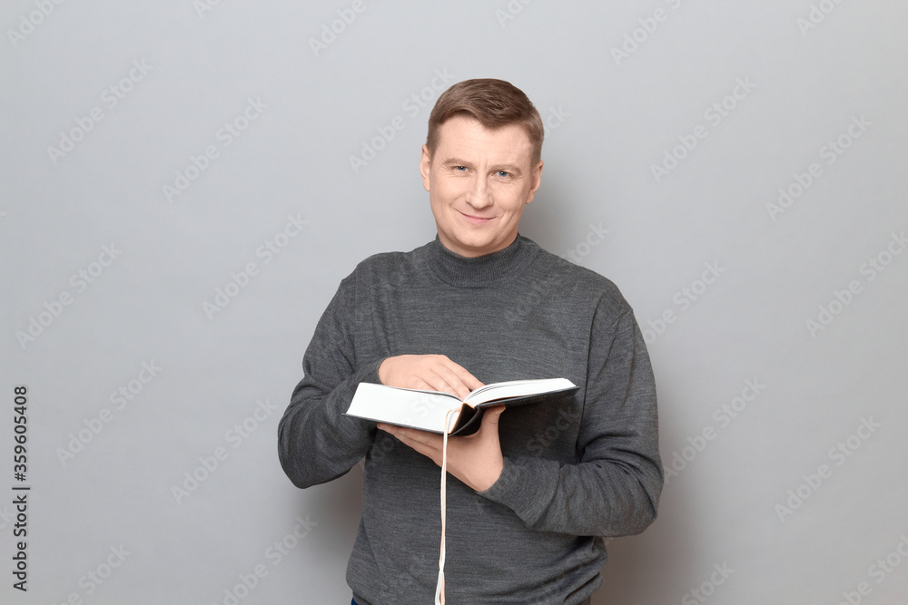 Portrait of happy man holding open big book in hands and smiling Portrait of happy man holding open big book in hands and smiling