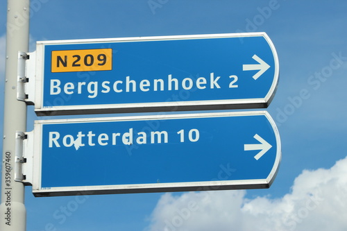 Blue and white signpost to Bergschenhoek village and Rotterdan town via provincial road N209 in Bleiswijk, the Netherlands.