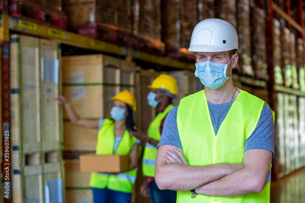 Group warehouse workers wearing protective mask to Protect Against Covid-19 working in industrial factory or warehouse. Group warehouse workers wearing protective mask to Protect Against Covid-19 working in industrial factory or warehouse.