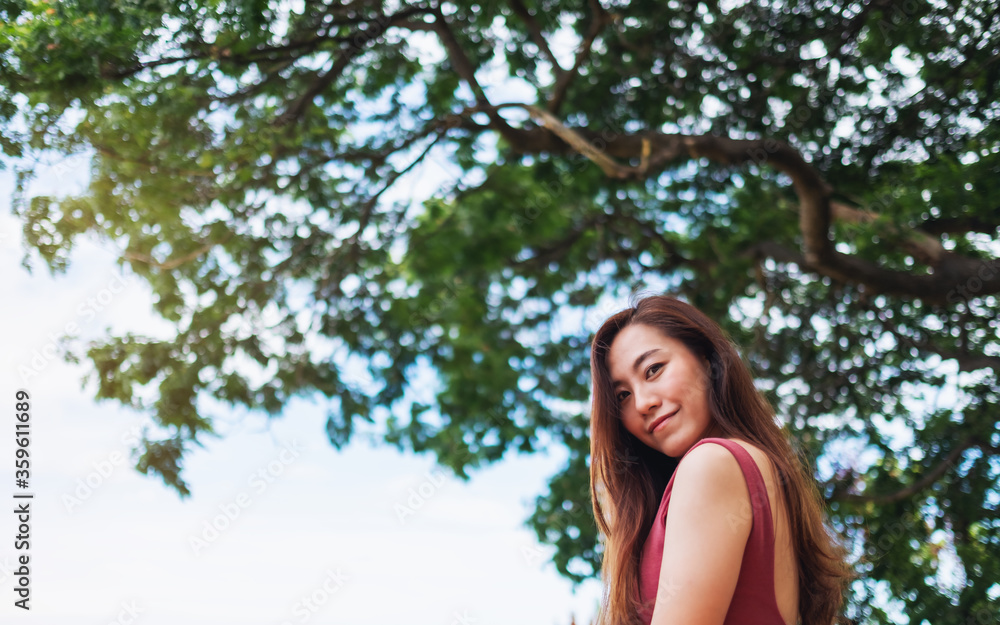 A beautiful young asian woman in the outdoors with blue sky background A beautiful young asian woman in the outdoors with blue sky background