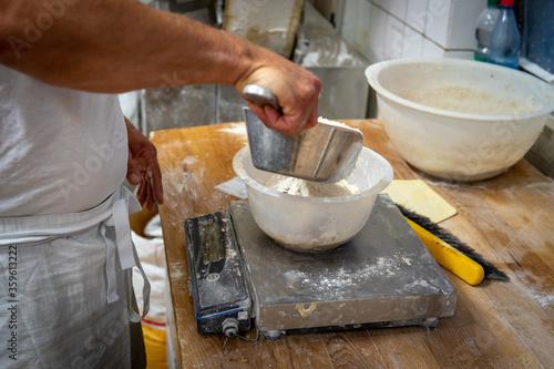 in bakery a baker mixes the ingredients for a bread dough