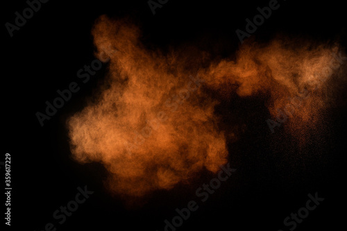 Orange powder explosion on black background. Colored powder cloud. Colorful dust explode. Paint Holi. © sergio34