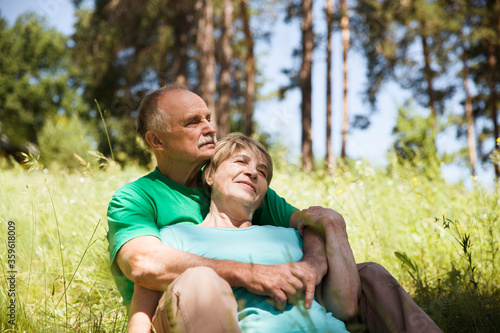 Portrait of attractive vibrant senior couple embracing in summer day outdoors. Staycations, hyper-local travel, family outing, getaway, natural environment