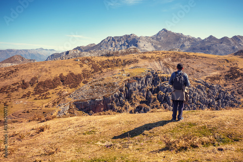A man stays on the top of the mount, looks at the beautiful panorama of the mountains. National Park Peaks of Europe. Cantabria, Spain, Europe