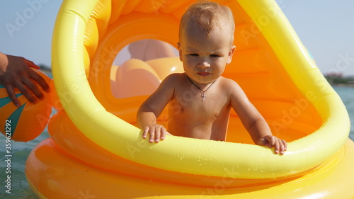 Portrait of little boy in big inflatable toy in the sea