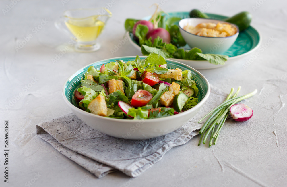Fattoush salad with lettuce, herbs, tomatoes, cucumber, red onion, radish and pieces of toasted pita bread. Middle Eastern cuisine. Fattoush salad with lettuce, herbs, tomatoes, cucumber, red onion, radish and pieces of toasted pita bread. Middle Eastern cuisine.