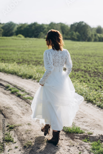 beautiful woman in long white dress posing in the field 