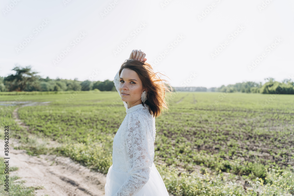 beautiful woman in long white dress posing in the field beautiful woman in long white dress posing in the field