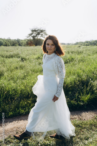 beautiful woman in long white dress posing in the field 