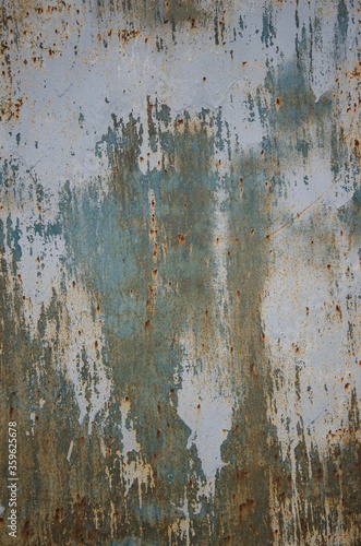 Old shabby paint with a blue tint on a metal background