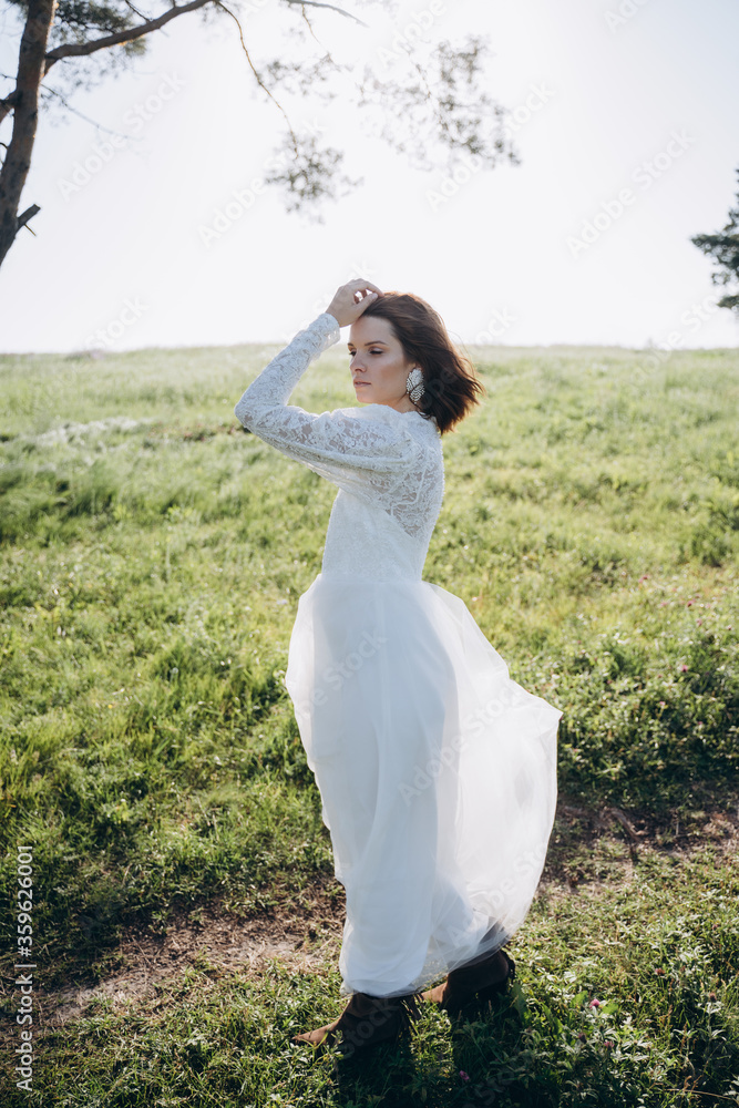 bride in white dress standing in green area