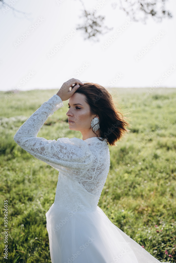 bride in white dress standing in green area bride in white dress standing in green area