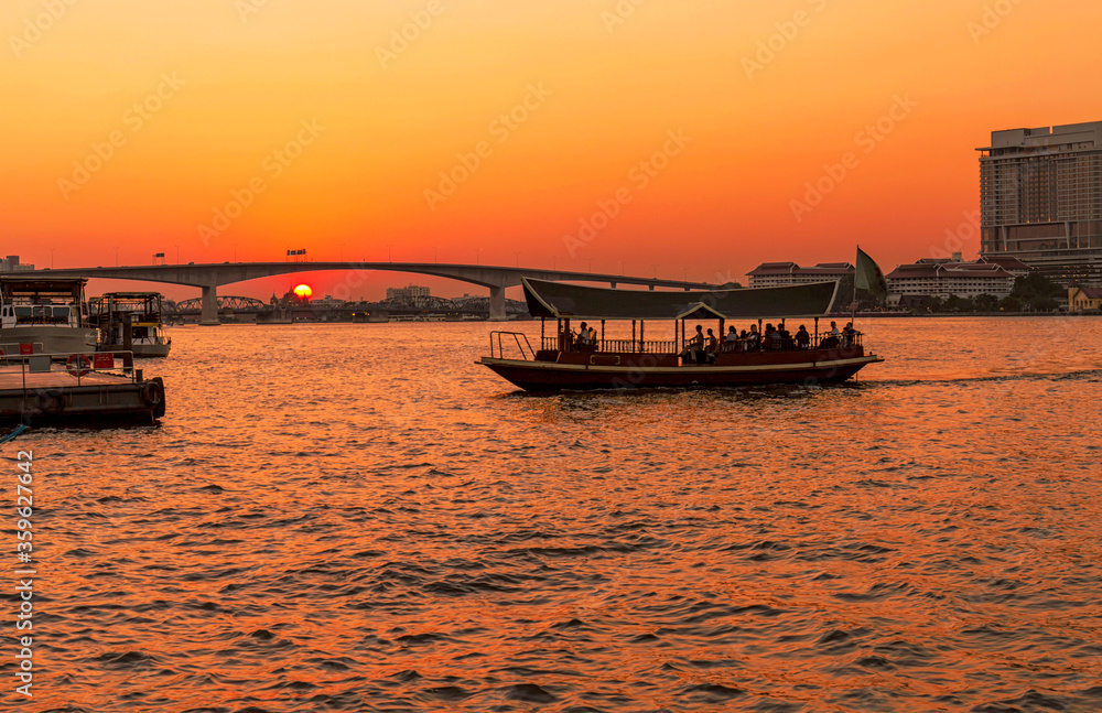 Dramatic sunset on river with bridge and boat in Chaophraya river, Bangkok, Thailand Dramatic sunset on river with bridge and boat in Chaophraya river, Bangkok, Thailand