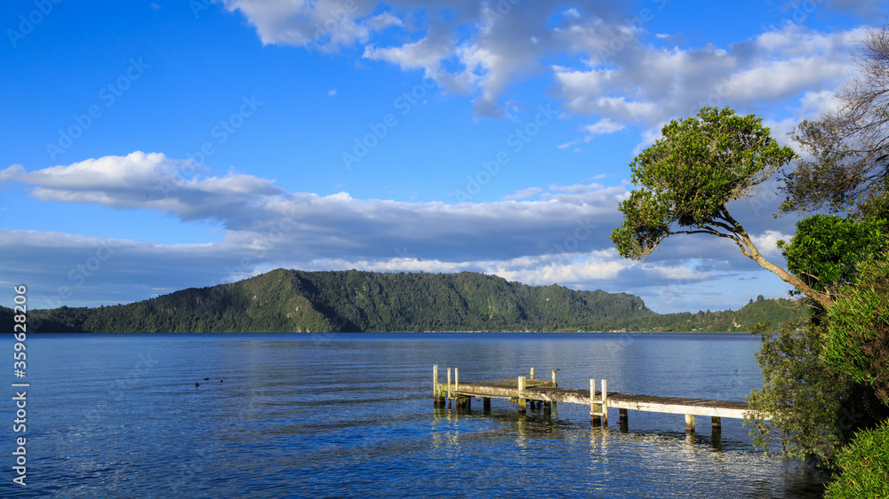 Wooden pier surrounded by native forest on Lake Rotoiti, New Zealand