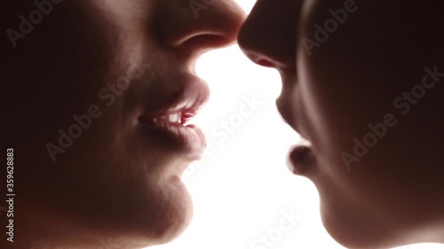Passionate kiss of lesbian girls close-up. White isolated studio background. LGBT relationships. photo