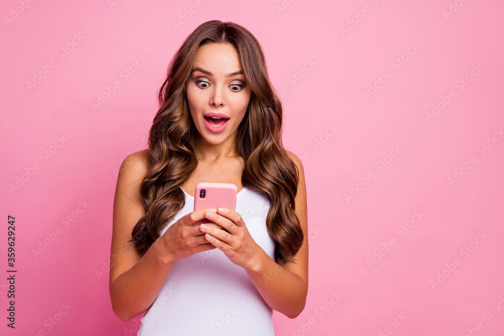 Photo of pretty wavy lady open mouth hold telephone hands chatting friends reading positive comments blog good mood wear white casual singlet isolated pink color background
