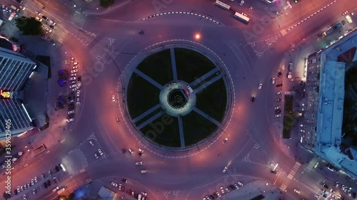 Hyperlapse timelapse of night city traffic. Drone spin over the intersection. Beautiful night lighting. Flight over the city. Traffic circle. Roads form a circle in architecture. View from above.