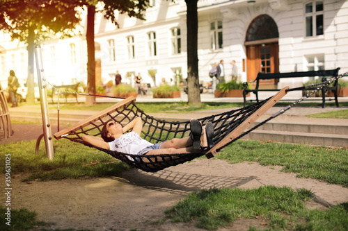 beautiful woman resting on hammock on the street in city