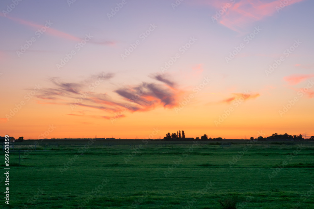 Beautiful pink colored cirrus clouds over the dutch countryside during the period of the longest days