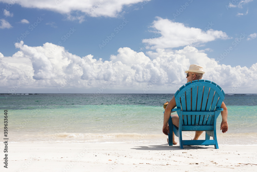 man in chair on Caribbian beach