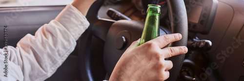 Tableau sur toile An unrecognizable female drinking beer while driving car